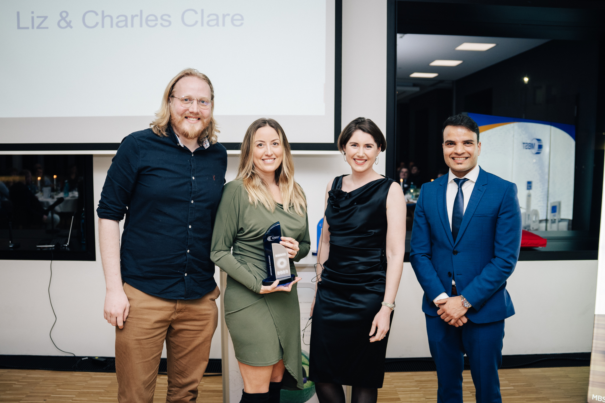 Liz und Charles Clare erhalten einen MBST-Award für MBST UK von Geschäftsführerin Sarah Hartmann und Stellvertretendem Geschäftsführer Jagadish Paudel